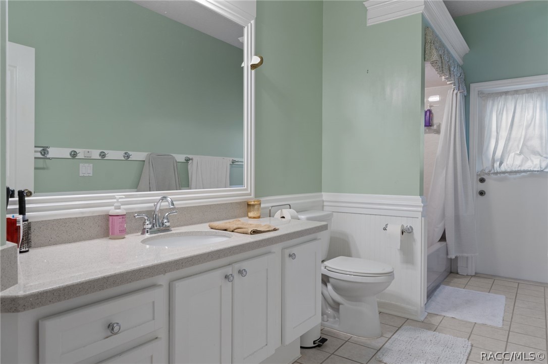 2460 West Pine Ridge Boulevard Beverly Hills, FL 34465 - Photo 31 of 47 a bathroom with a double vanity sink toilet and a mirror