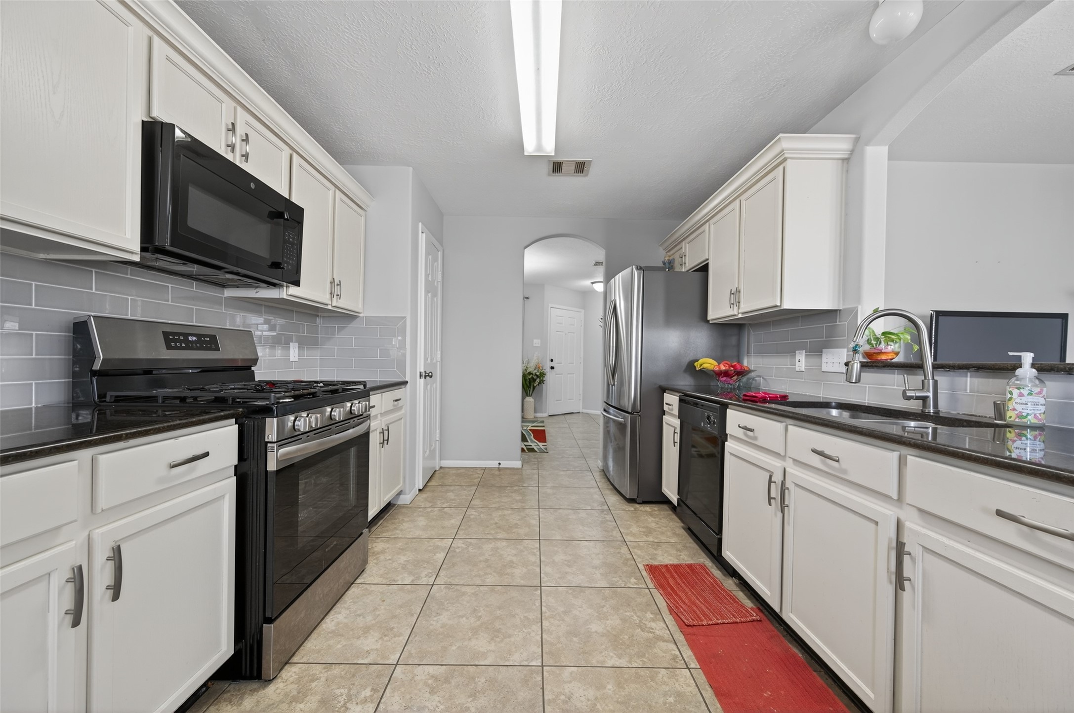 19655 Perth Meadows Court Katy, TX 77449 - Photo 20 of 44 a kitchen with stainless steel appliances granite countertop a stove top oven a sink dishwasher a refrigerator and a microwave