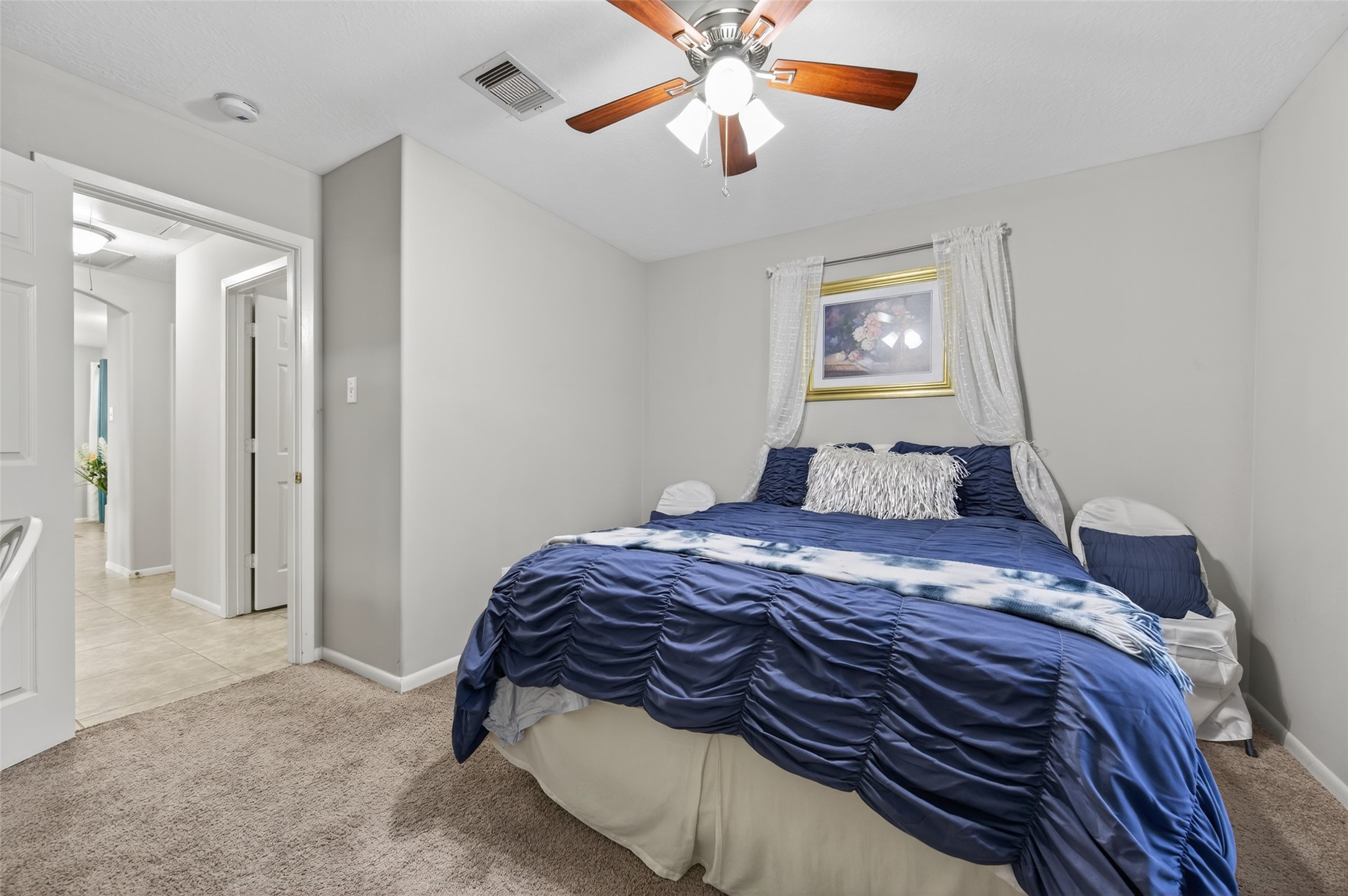 19655 Perth Meadows Court Katy, TX 77449 - Photo 31 of 44 a bedroom with a bed and a chandelier