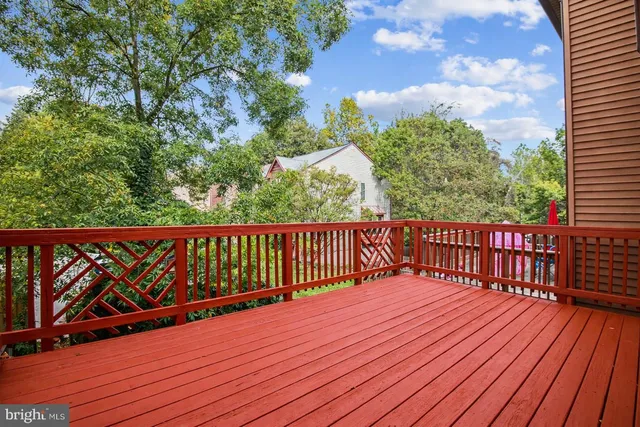 a balcony with wooden floor and trees in the back