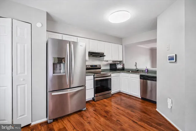 a kitchen with a refrigerator and a stove top oven