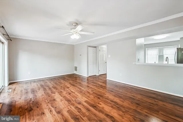 a view of empty room with wooden floor