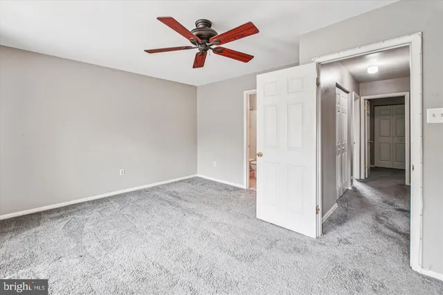 an empty room with closet and fan