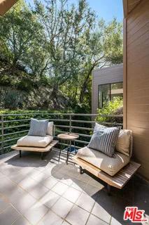 a roof deck with couches and wooden fence