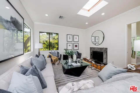 a living room with furniture a fireplace and a large window