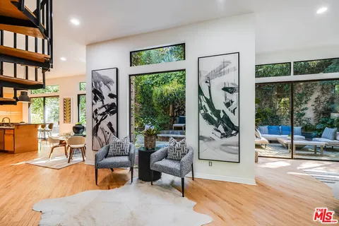 a living room with furniture a large window and book shelf