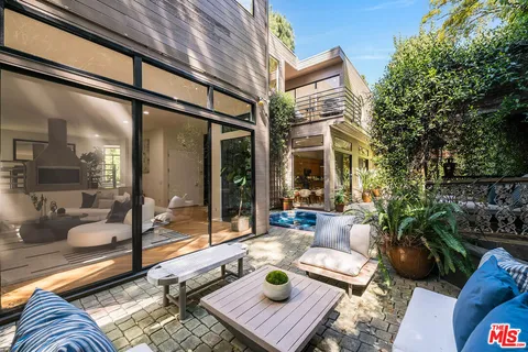 a view of a patio with couches table and chairs and potted plants