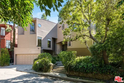 a front view of a house with plants