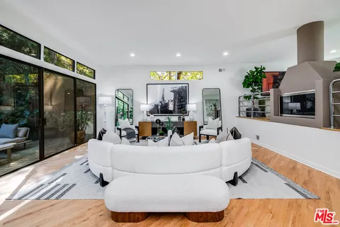 a living room with fireplace furniture and a floor to ceiling window