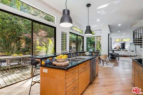 a kitchen with stainless steel appliances granite countertop sink stove and wooden floor