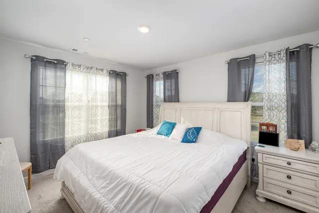 a bedroom with a large bed and a window