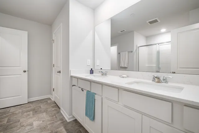 a bathroom with double sink and a mirror