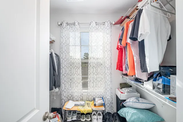 a view of walk in closet with clothes and shoes