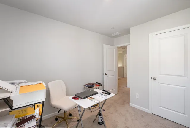 a view of a workspace with furniture and a window