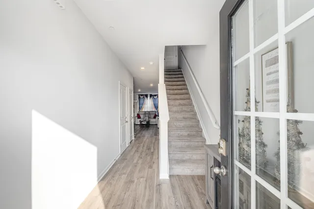 a view of entryway and hall with wooden floor