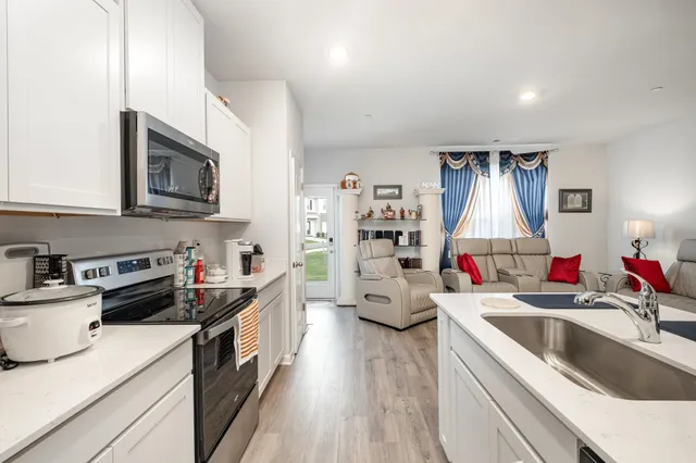 a kitchen that has a lot of cabinets and wooden floor
