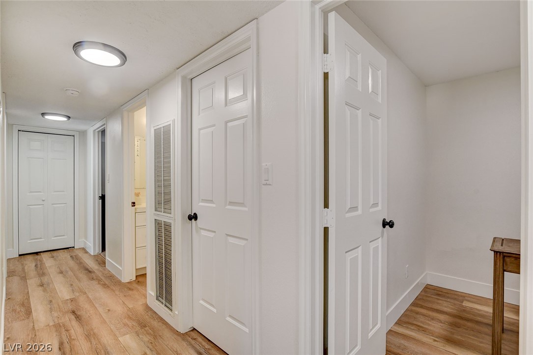 4362 Thistle Street Logandale, NV 89021 - Photo 53 of 99 A well-lit corridor with warm wood-tone LVP flooring connects various rooms.
