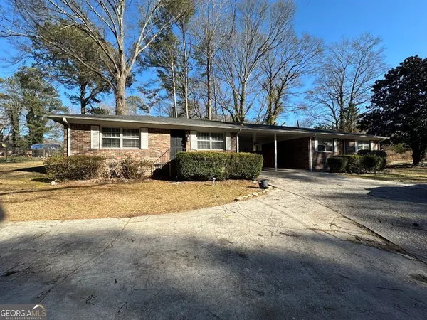 a front view of house with yard and trees around