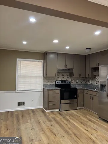 a kitchen with kitchen island granite countertop a stove and a sink