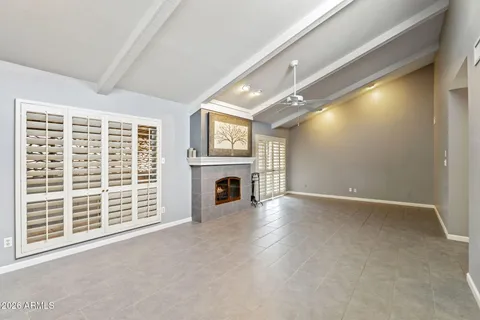 a view of an empty room with a fireplace and a window