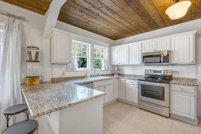 a kitchen with stainless steel appliances granite countertop a sink stove and microwave