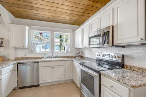 a kitchen with stainless steel appliances granite countertop white cabinets a sink and dishwasher