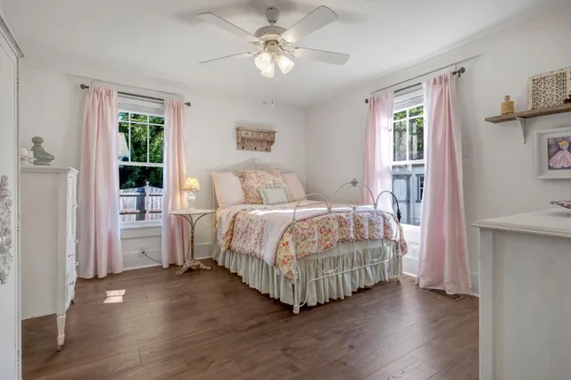 a bedroom with a large bed a chandelier and windows