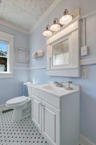 a bathroom with a sink a toilet and mirror
