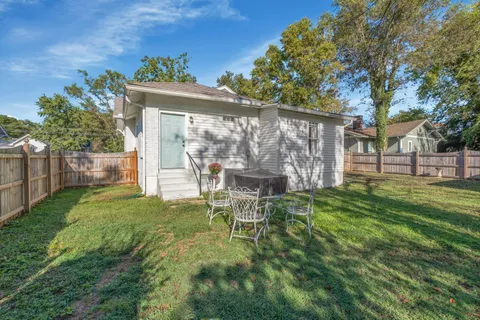 a view of a chair and table in backyard of the house