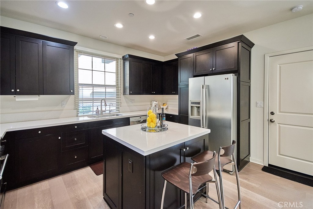 129 Excursion Irvine, CA 92618 - Photo 7 of 53 a kitchen with stainless steel appliances granite countertop a refrigerator a sink a stove a dining table and chairs