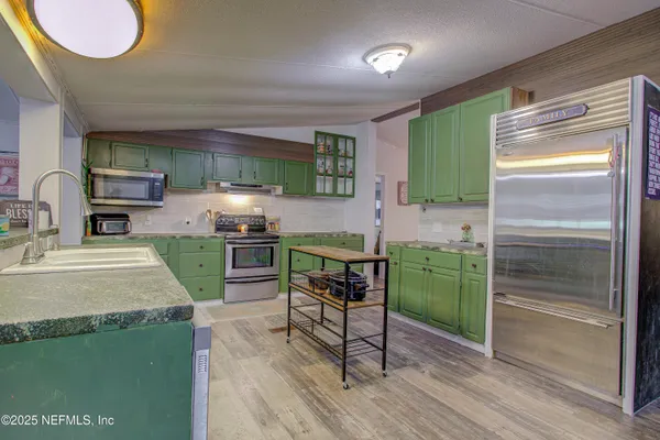 a kitchen with cabinets a counter top space and stainless steel appliances
