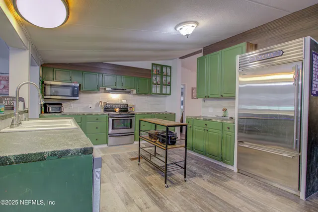 a kitchen with cabinets a counter top space and stainless steel appliances