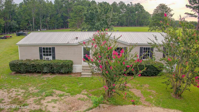 a view of a house with a big yard and potted plants