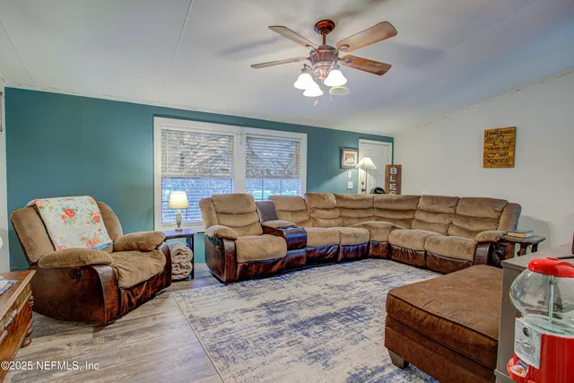 a living room with furniture a chandelier and a window