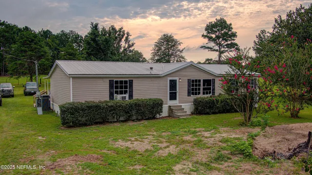 a view of a big yard with a house in the background