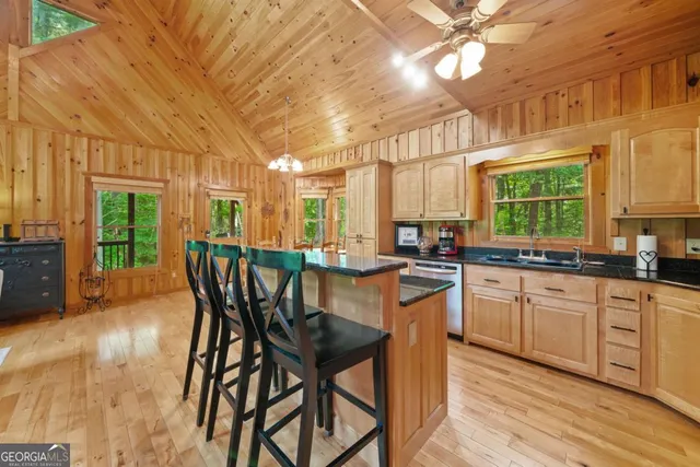 a kitchen with stainless steel appliances granite countertop table chairs sink and cabinets