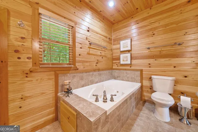 a bathroom with a tub and a toilet