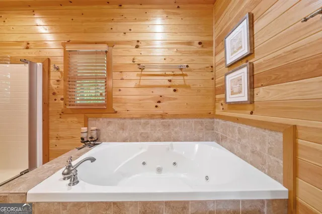 a bathroom with bathtub next to a window
