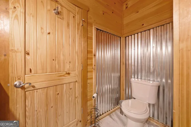 a bathroom with a granite countertop shower and a toilet