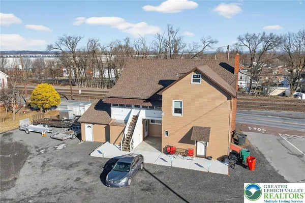 an aerial view of a house with swimming pool and seating
