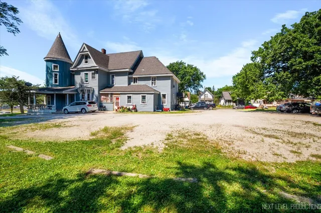 a view of a house with a big yard and large trees