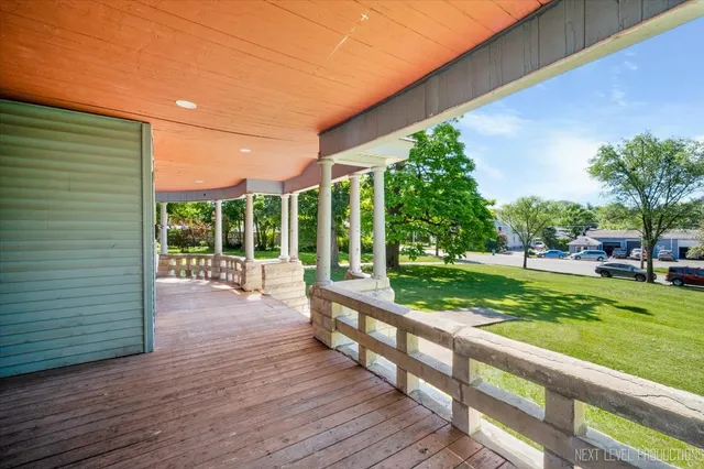 a view of a porch with wooden floor and fence