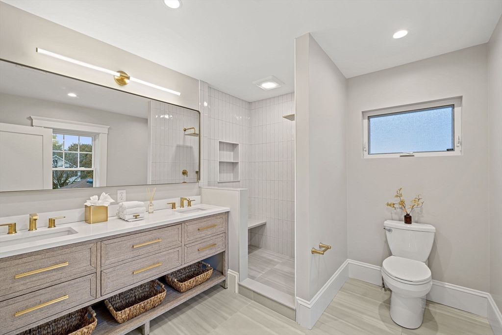 53 Highland Avenue Arlington, MA 02476 - Photo 19 of 34 a bathroom with a toilet sink double vanity and mirror