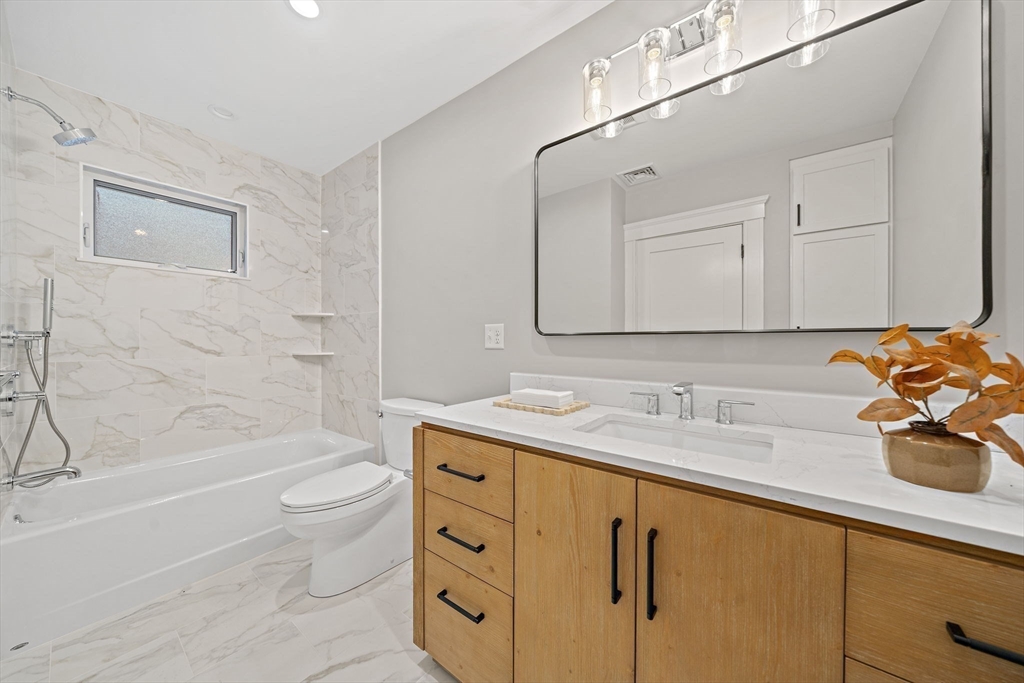 53 Highland Avenue Arlington, MA 02476 - Photo 25 of 34 a bathroom with a granite countertop sink a toilet and bathtub