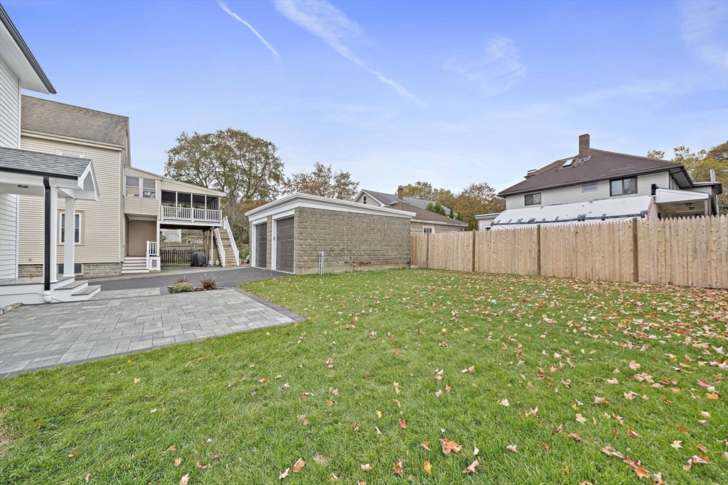 53 Highland Avenue Arlington, MA 02476 - Photo 32 of 34 a view of a house with a backyard and a garage