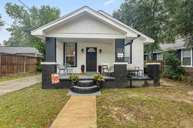 a view of a house with backyard sitting area and garden