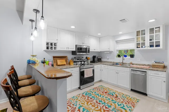 a kitchen with stainless steel appliances granite countertop a sink and cabinets
