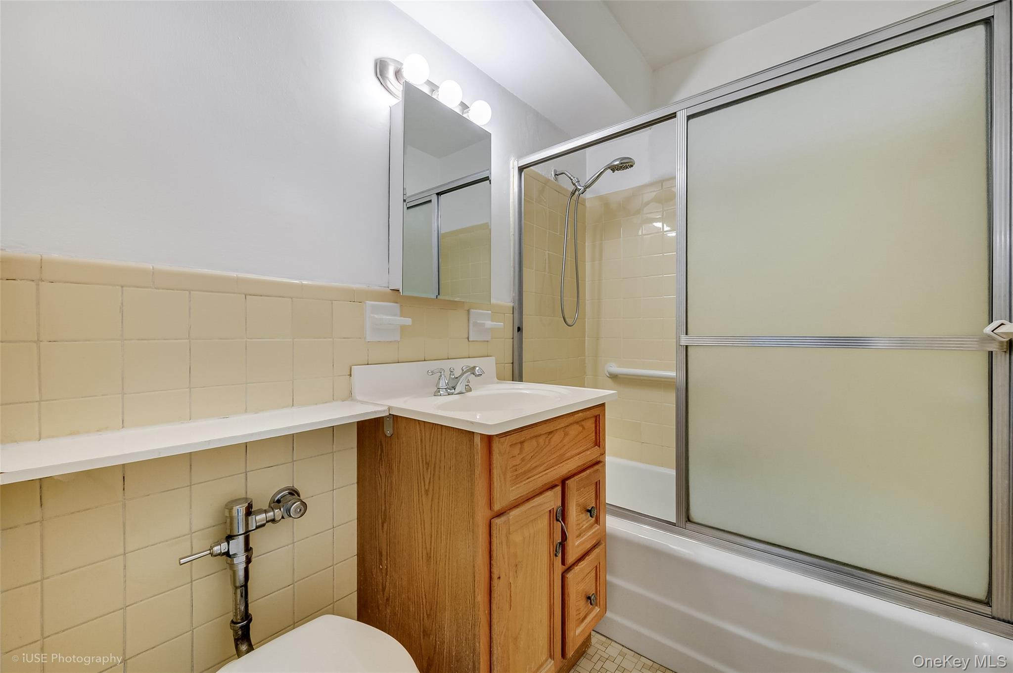 39-65 52nd Street, Unit 2H Queens, NY 11377 - Photo 7 of 18 a bathroom with a sink mirror vanity and toilet