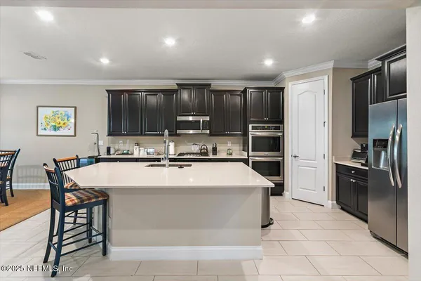 a kitchen with kitchen island a counter top stainless steel appliances and cabinets