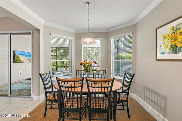 a view of a dining room with furniture a chandelier and wooden floor